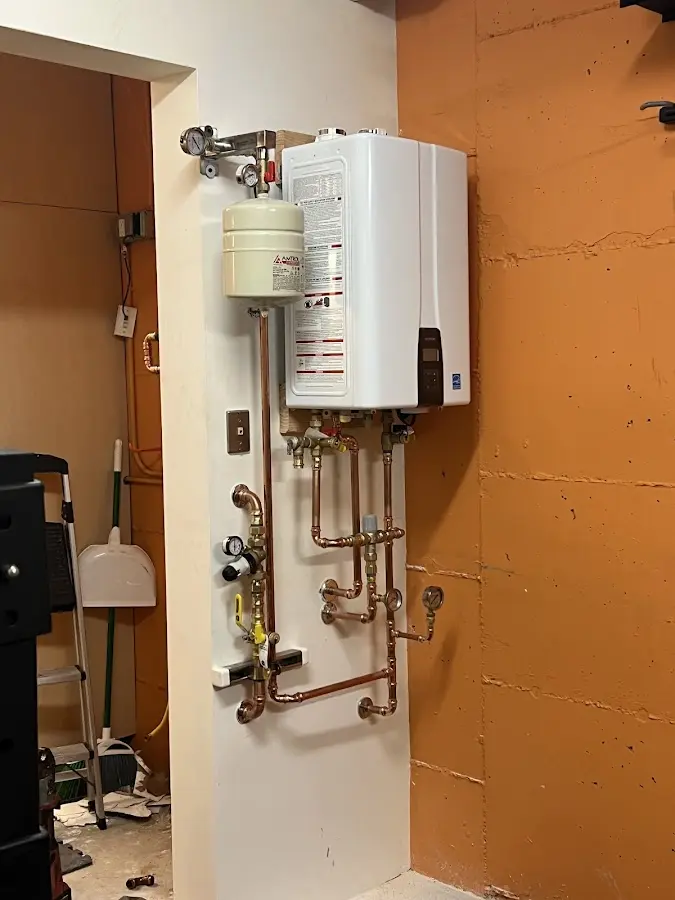 Plumbing technician inspecting water heater connections in Souderton